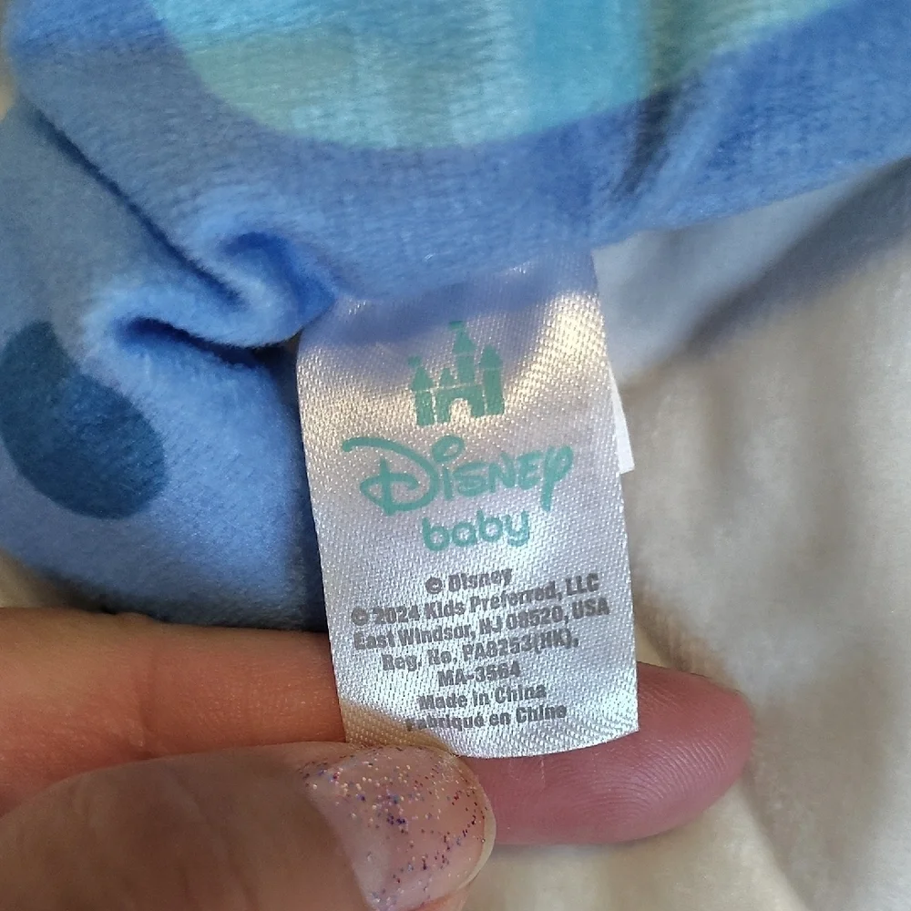 Disney Stitch Holding A Duck Soother Plush With Squeaker And Crinkle Material.
